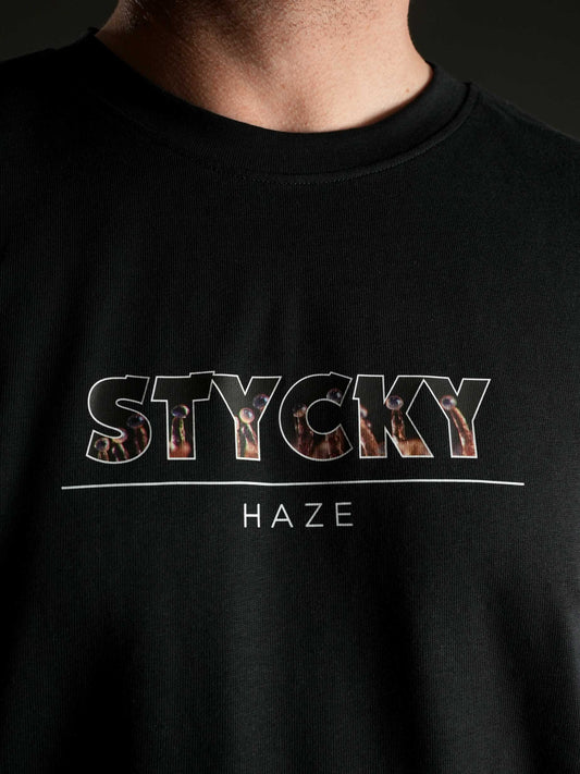 Nahaufnahme des auffälligen ‚STYCKY Haze‘ Motivs auf dem schwarzen T-Shirt