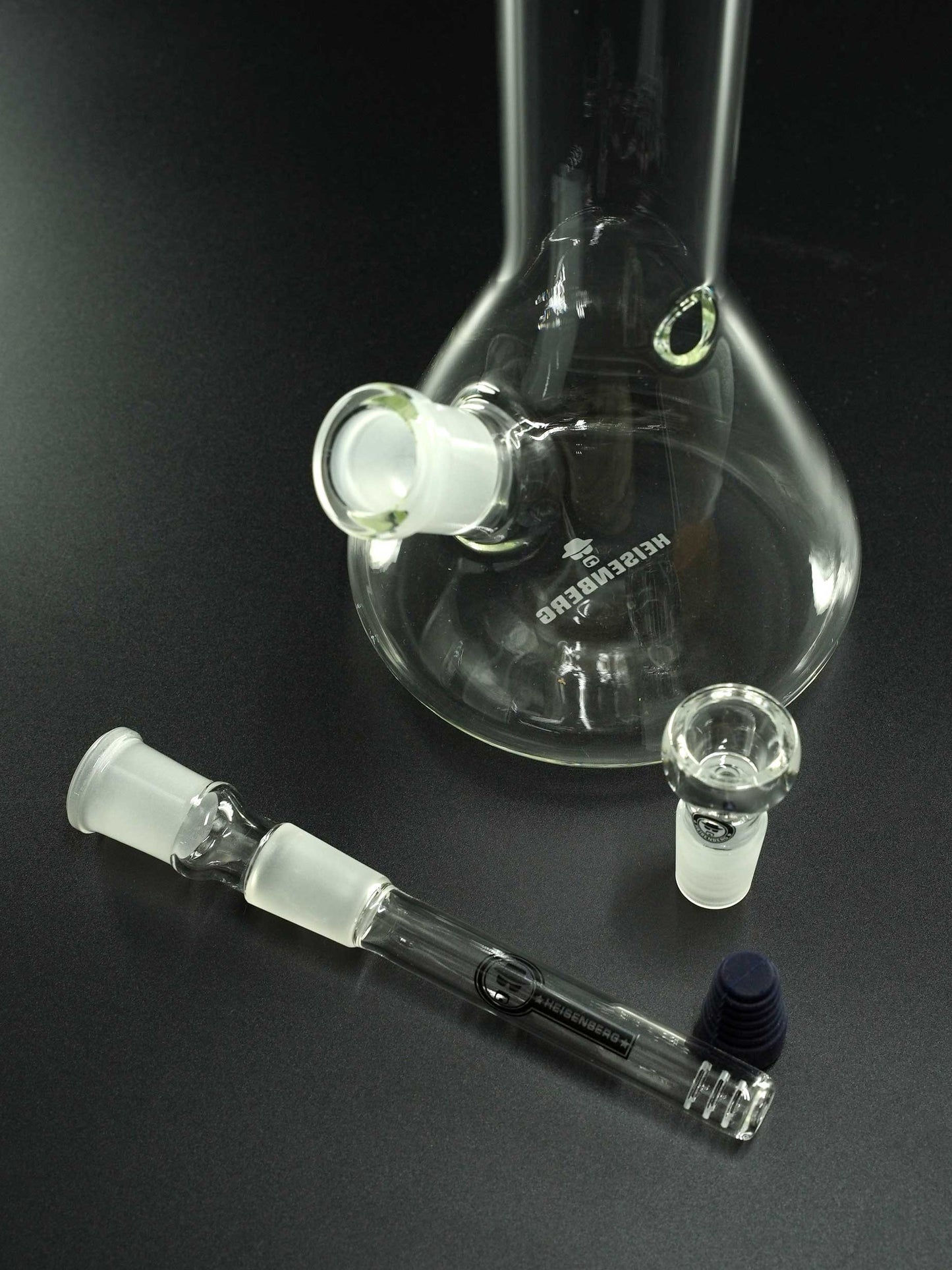 „Lieferumfang der Heisenberg Little Bitch Bong: Glaskörper, 18.8 > 18.8 mm Schlitzloch-Diffusor-Chillum und 18.8 mm Kopf.