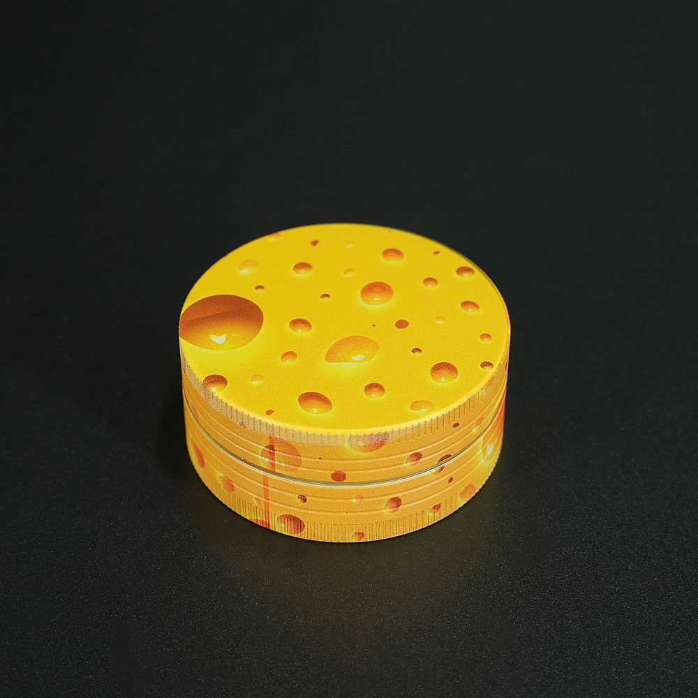 Auffälliger Cheese-Print auf dem Deckel macht diesen Champ Grinder zum Hingucker – kompakt, funktional und geschmackvoll im Design