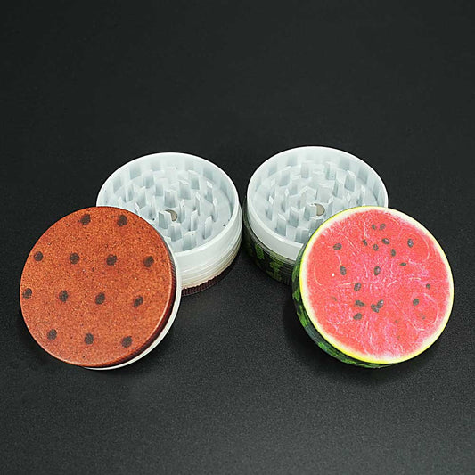 Zweiteiliger Grinder von Champ, geöffnet dargestellt: Ober- und Unterteil mit robustem Mahlwerk und farbigem Motivdeckel